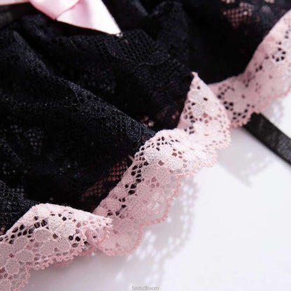 Close-up of black lace corset lingerie set with pink bow and ruffled skirt trim, showcasing French maid style and delicate lace details.