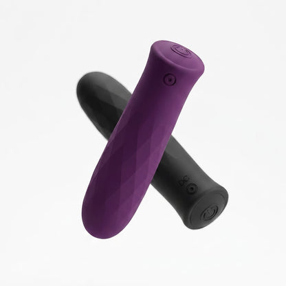 High-key artistic composition featuring a floating purple massager at an angle, with a black massager suspended in the background at a different depth. 